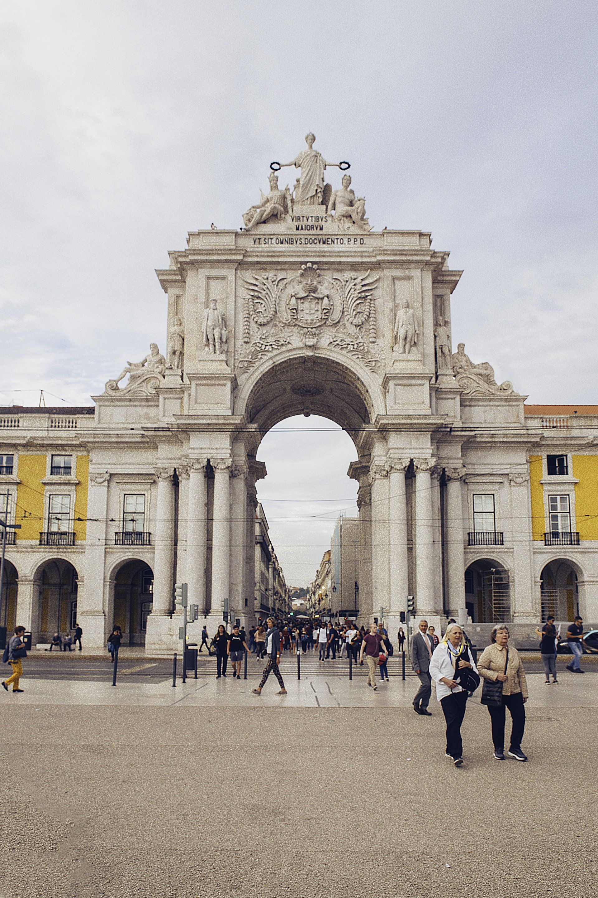 A group of people are standing in front of a large archway.