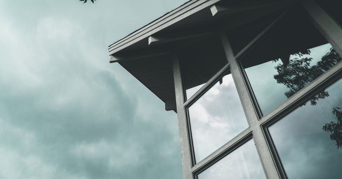 A building with a lot of windows against a cloudy sky.