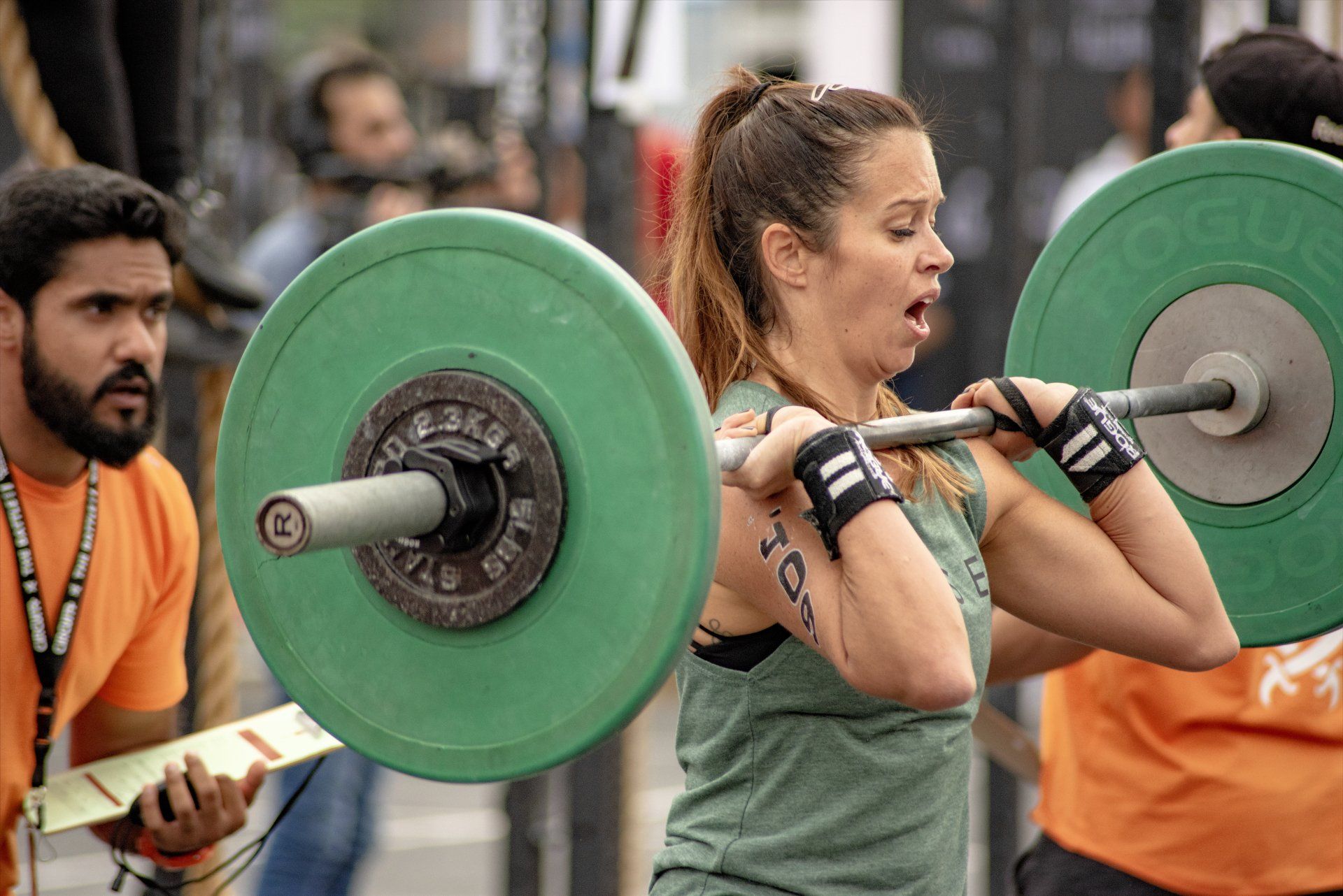 A woman is squatting with a barbell on her shoulders.