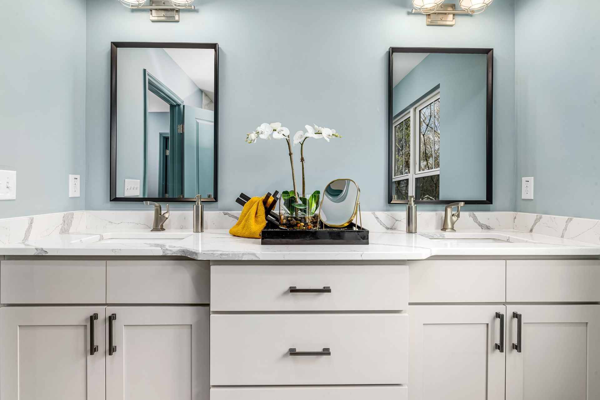 A bathroom with two sinks and two mirrors.