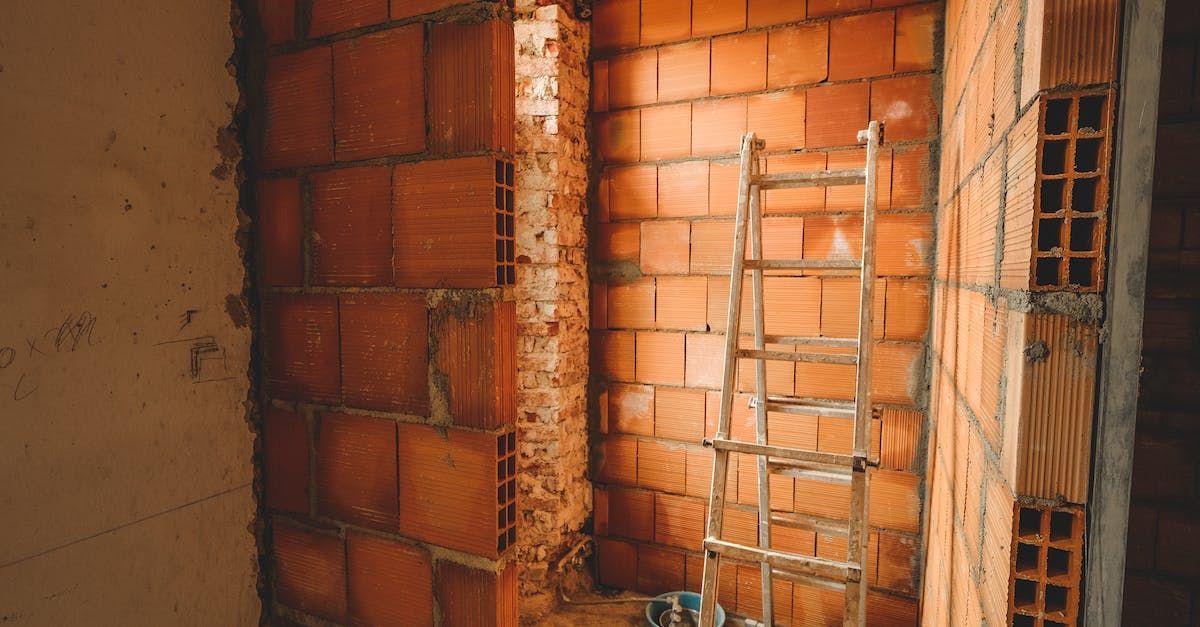 A ladder is sitting in a room with brick walls.