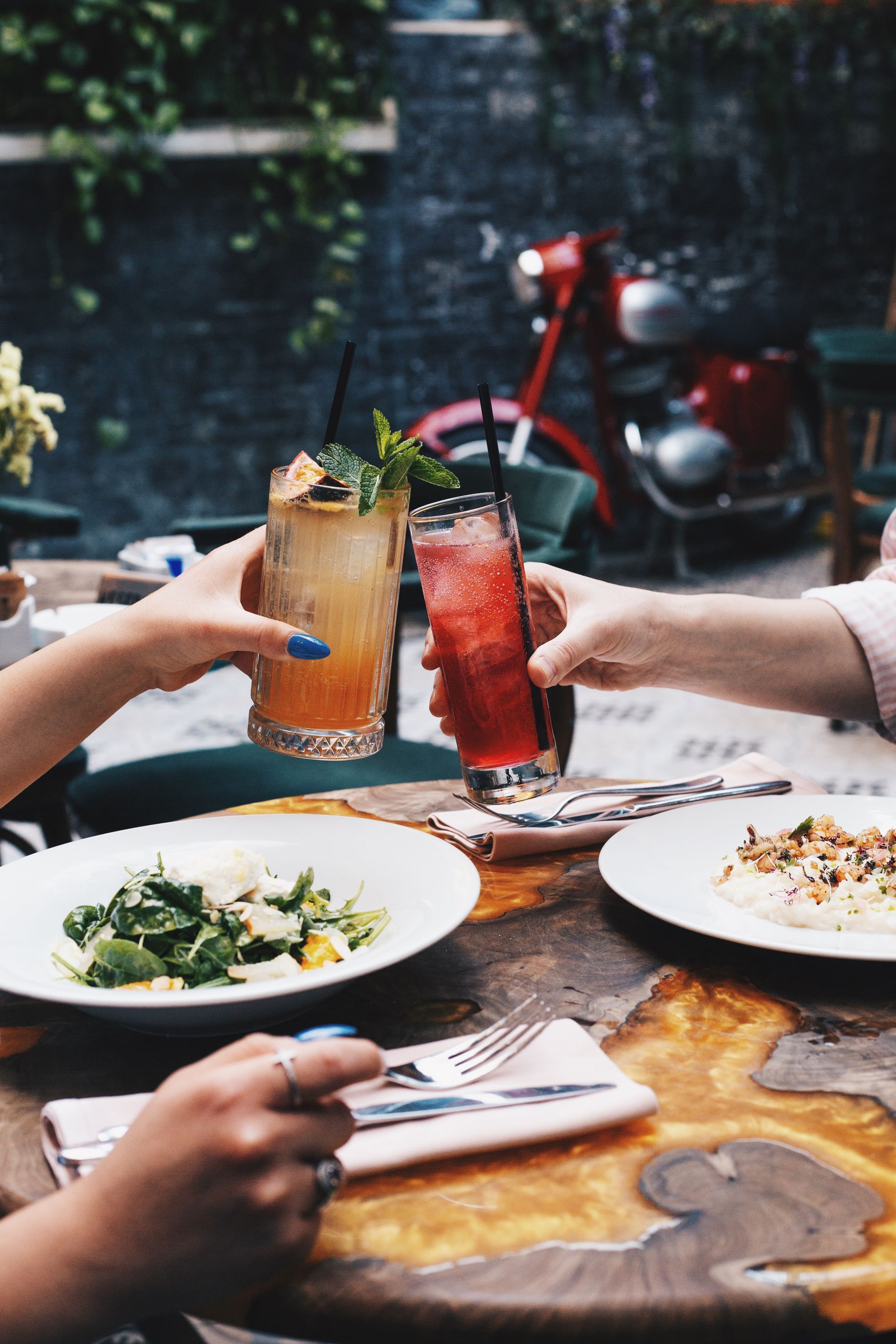 A group of people are sitting at a table with plates of food and drinks.