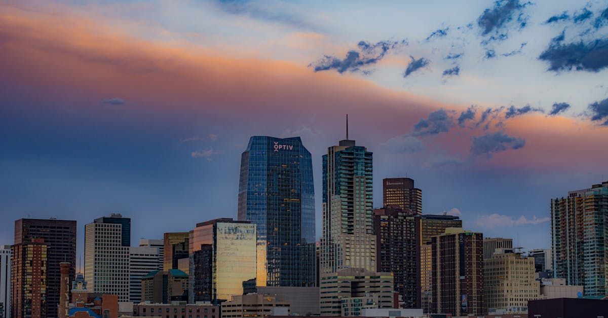 City skyline at sunset with blue, orange, and purple hues in the sky.