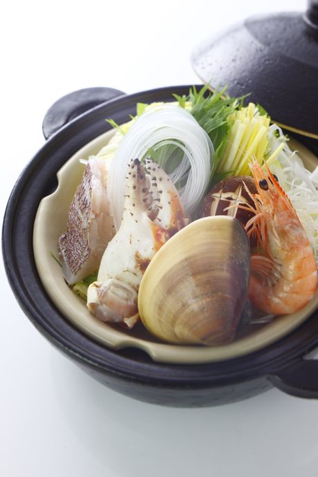Una pentola piena di frutti di mare e verdure su un tavolo.