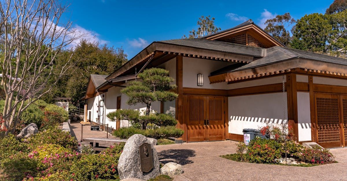 a large white house with a wooden roof is surrounded by trees and bushes. peter lama lend18 mortgage