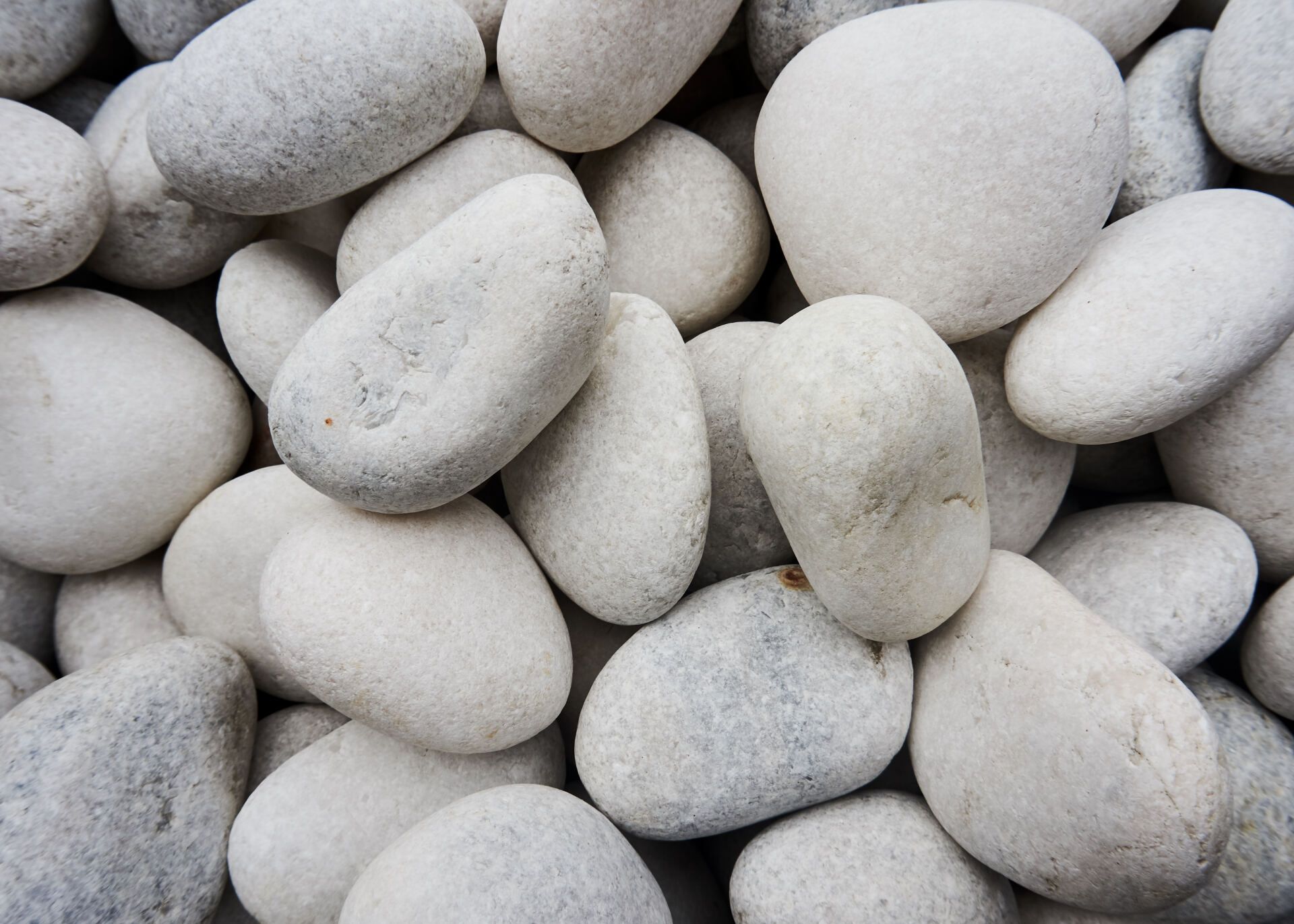 Close-up of smooth white and gray pebbles filling the frame