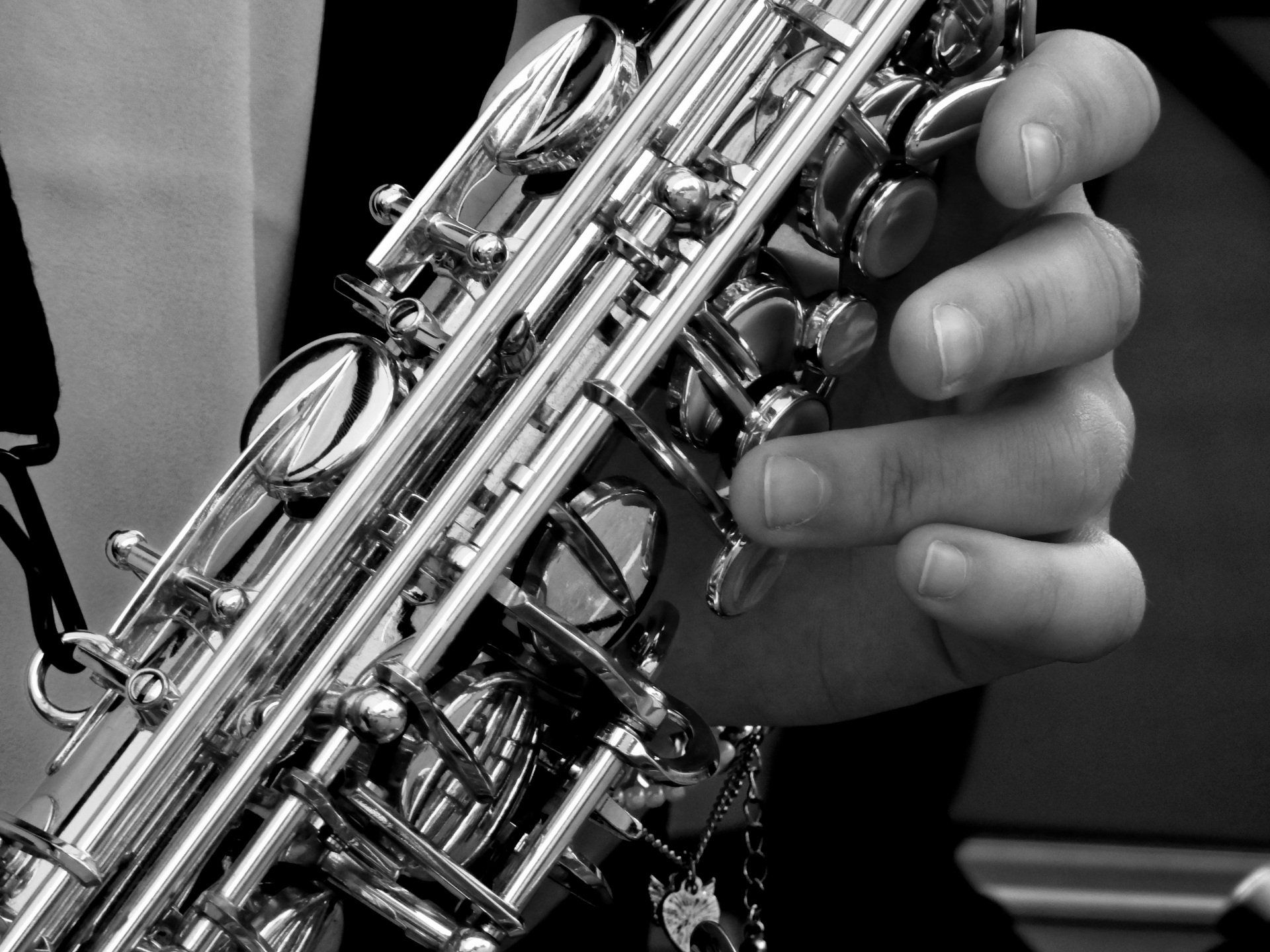 A person is playing a saxophone in a black and white photo