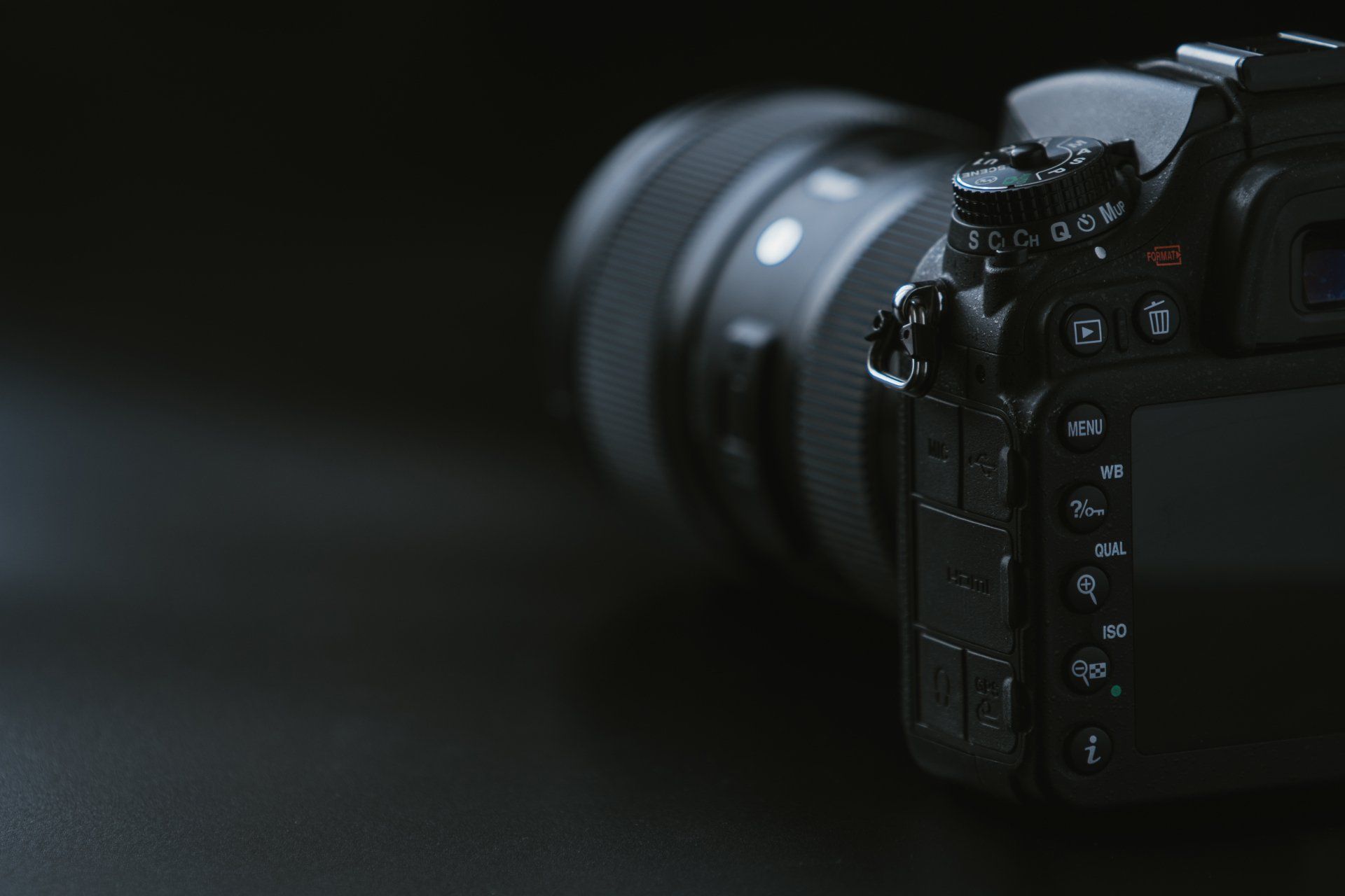 A close up of a camera with a lens on a black background.