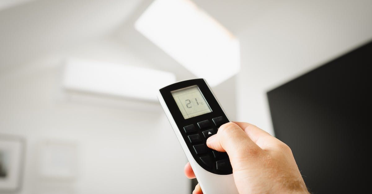 A person is holding a remote control in their hand.