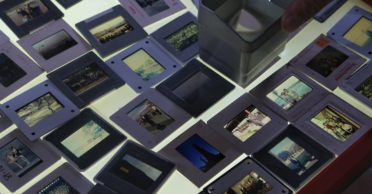 Display of assorted framed photographs and prints arranged in a grid on a table or wall.