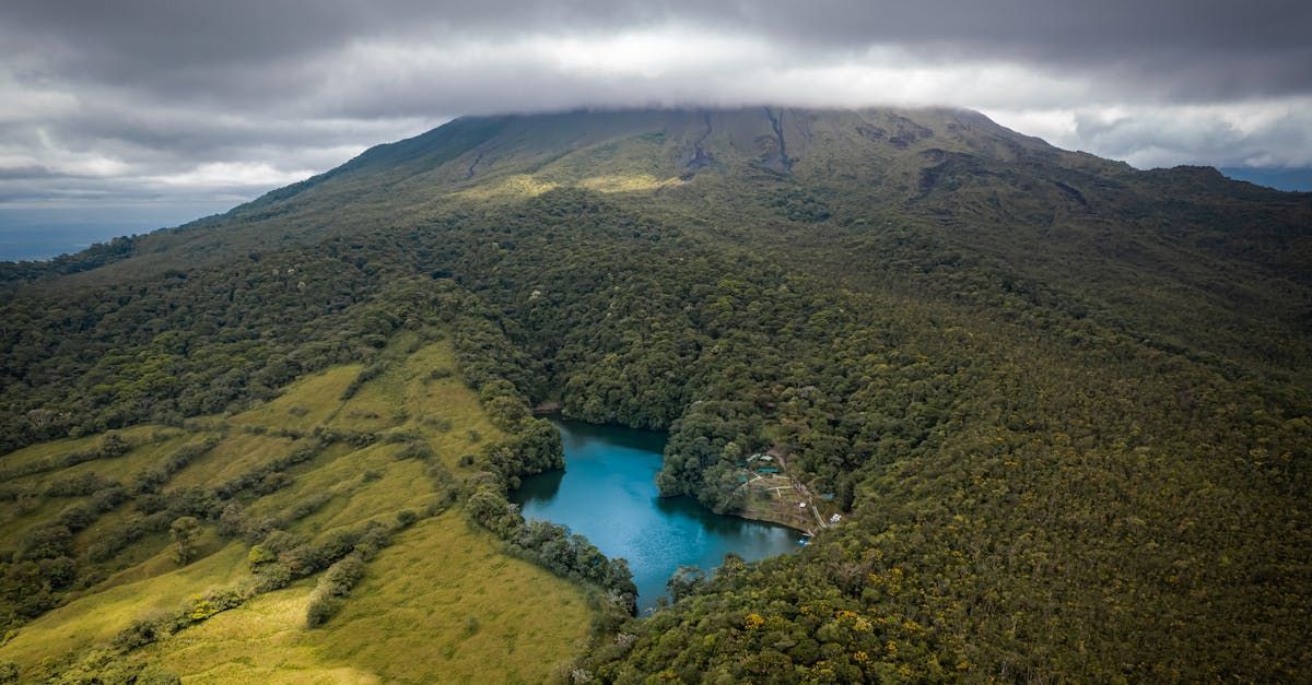 An aerial view of a lake surrounded by mountains and trees.