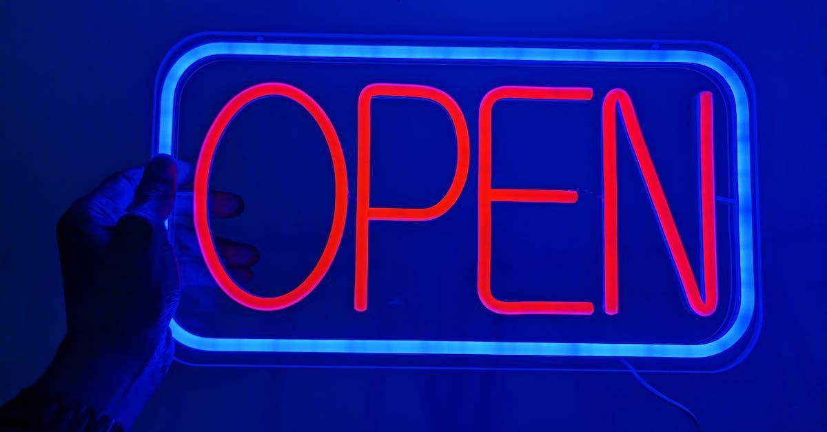 Hand holding a glowing neon sign that says