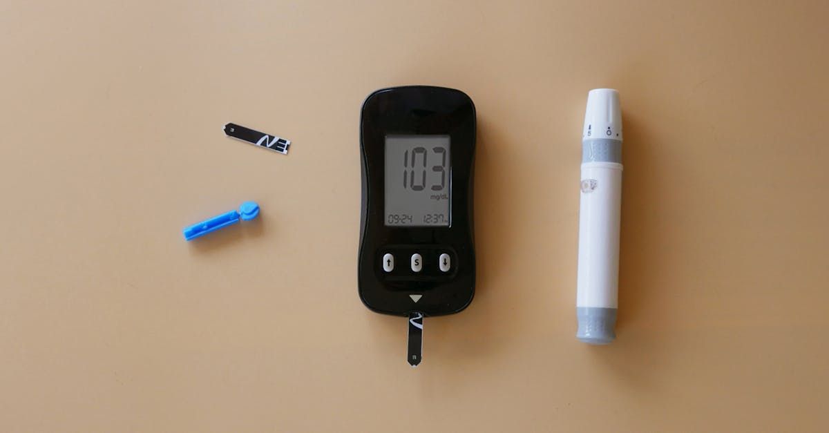 Een bloedglucosemeter die 103 weergeeft, met een prikpen en twee lancetten op een beige oppervlak.