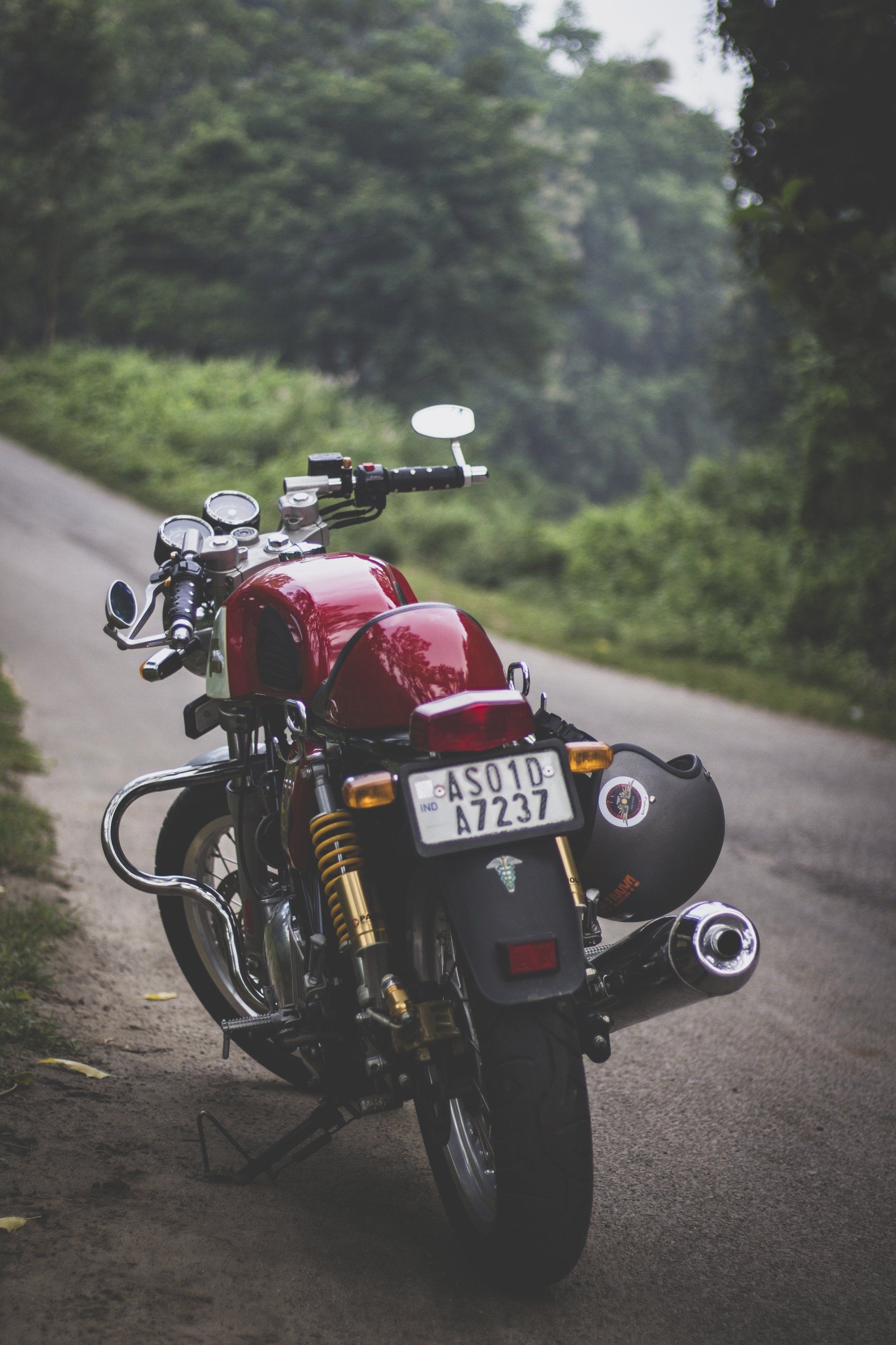 A red motorcycle is parked on the side of a road.