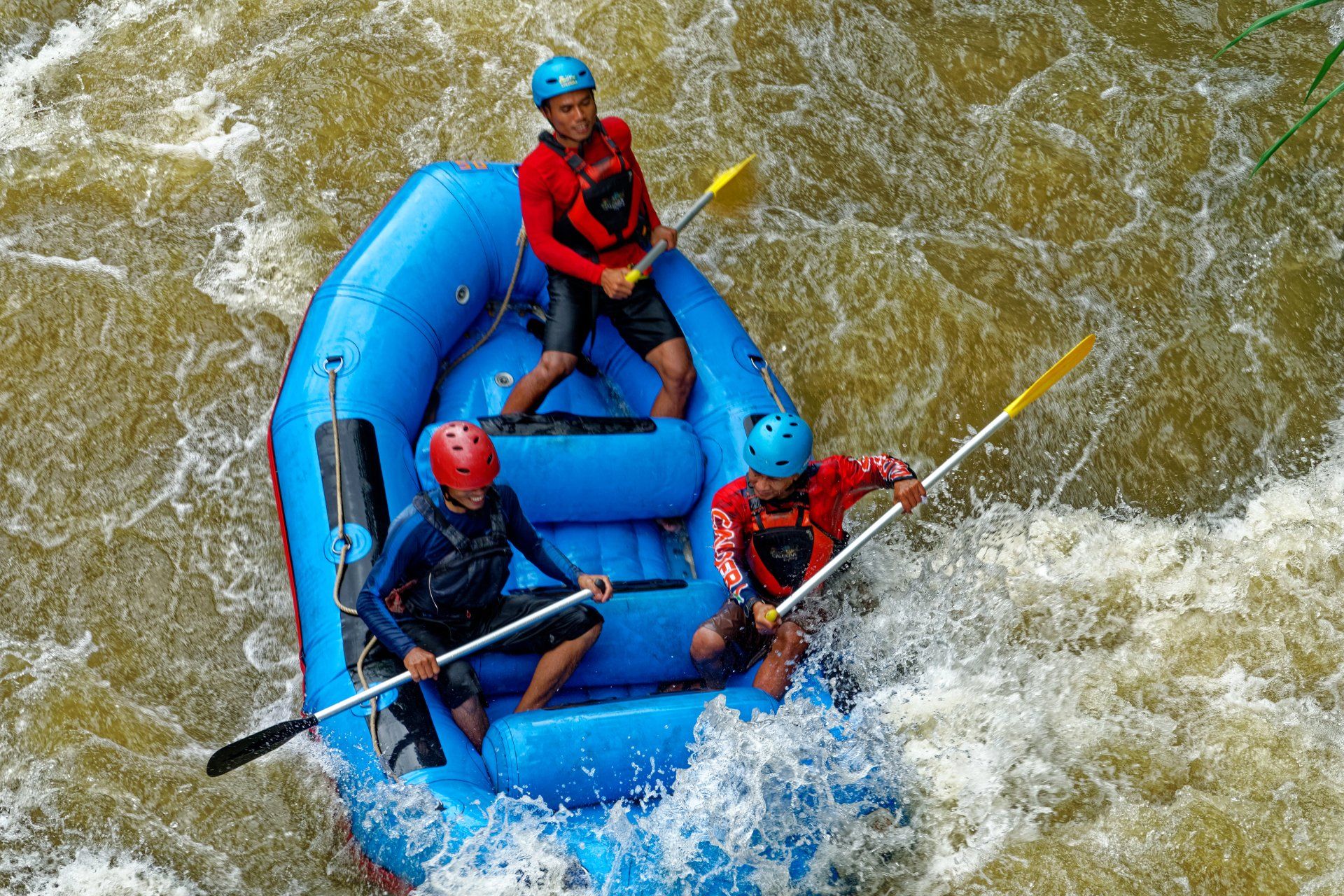 a group of people are rafting down a river in a blue raft .