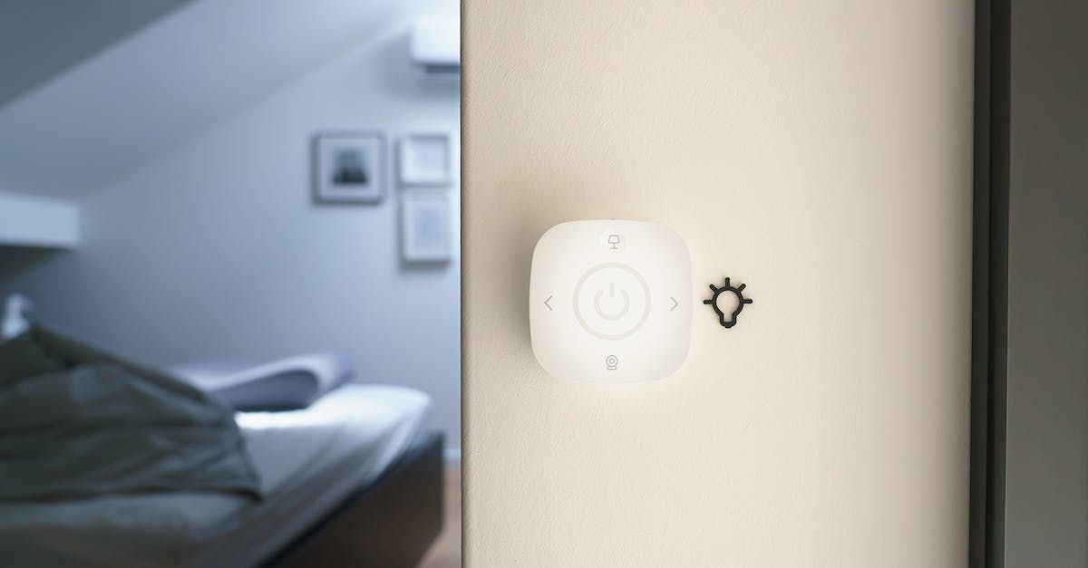 A bedroom with a bed and a light switch on the wall.