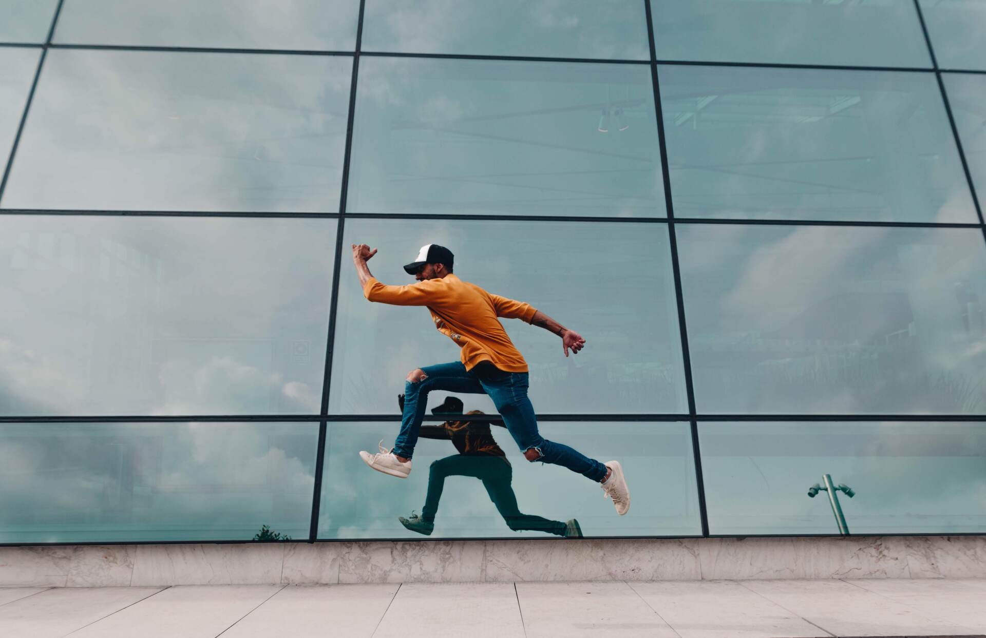 A man is jumping in the air in front of a building.