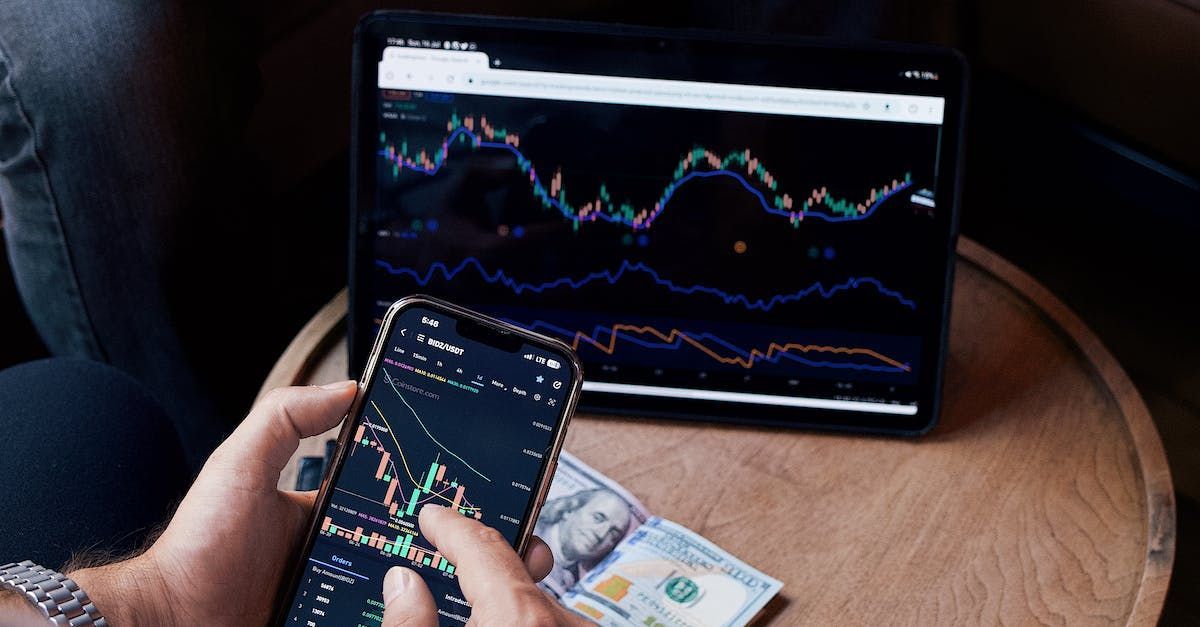 a person is holding a cell phone and looking at a graph
