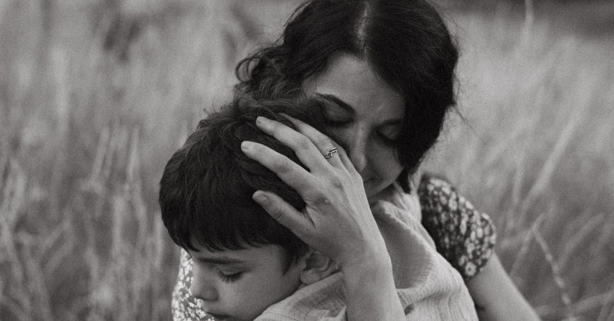 A woman is holding a child in her arms in a field.