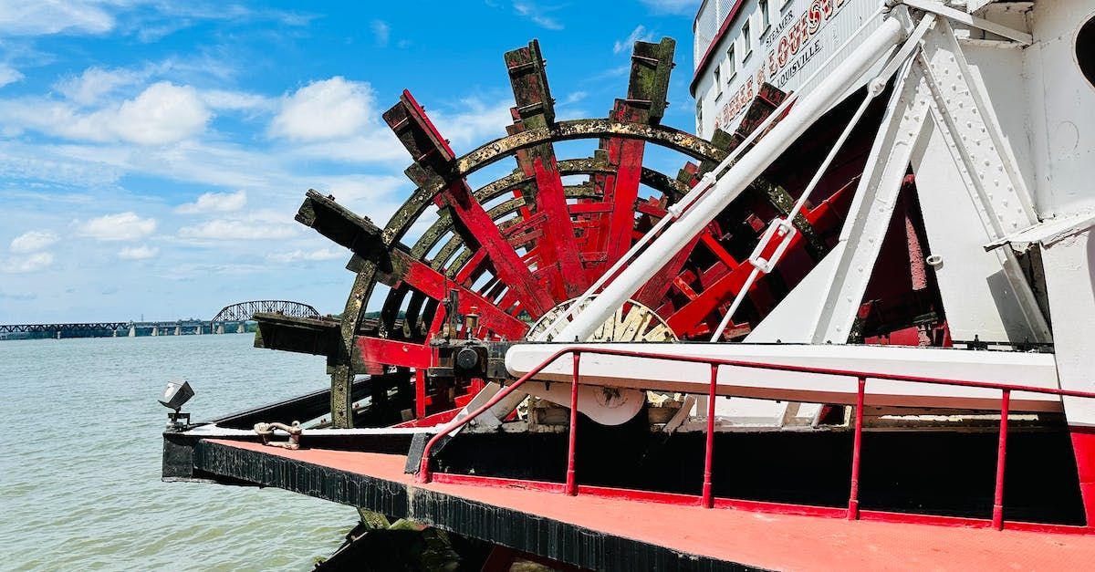 A large wheel on the side of a boat in the water.