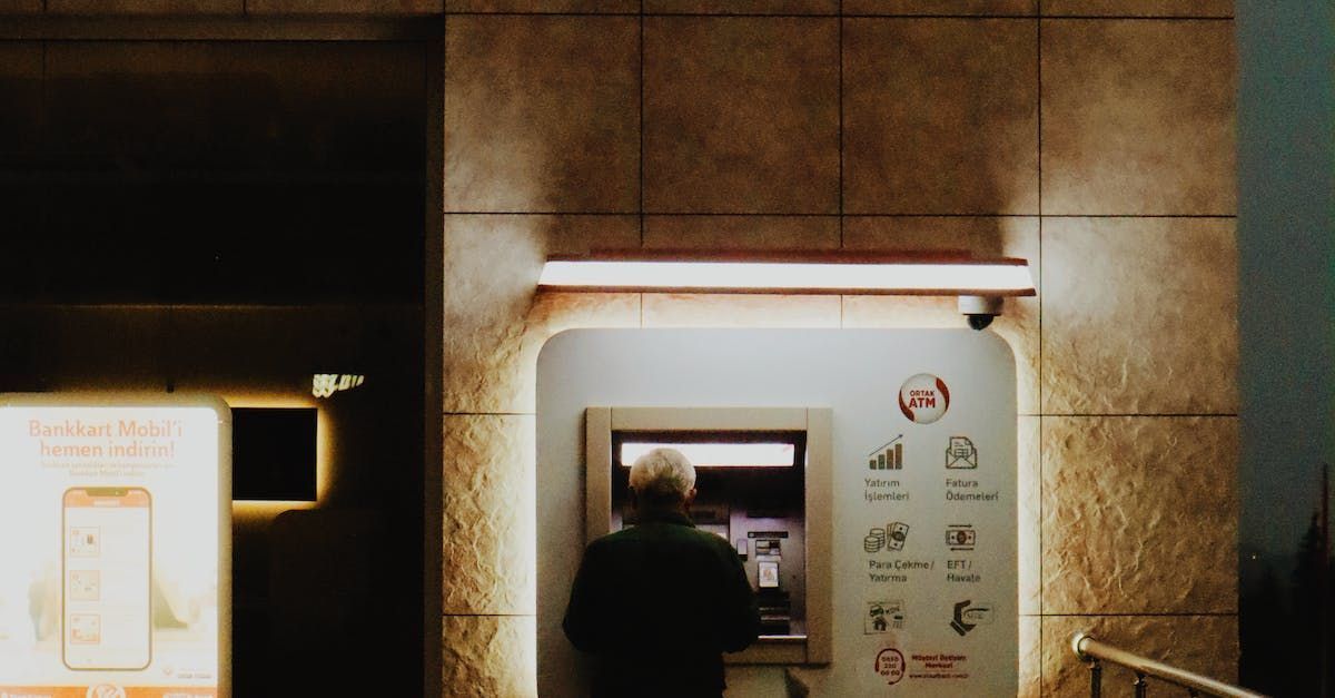 Click here for in-depth information about Sky-Walker in finance! A man standing in front of an ATM machine in a financial banking building