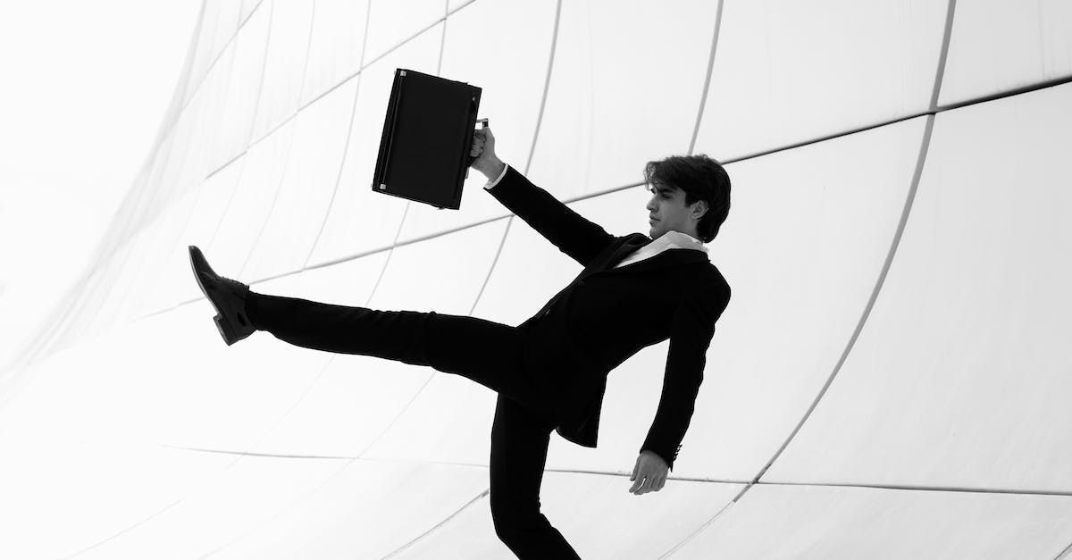 A man in a suit is falling down while holding a briefcase.