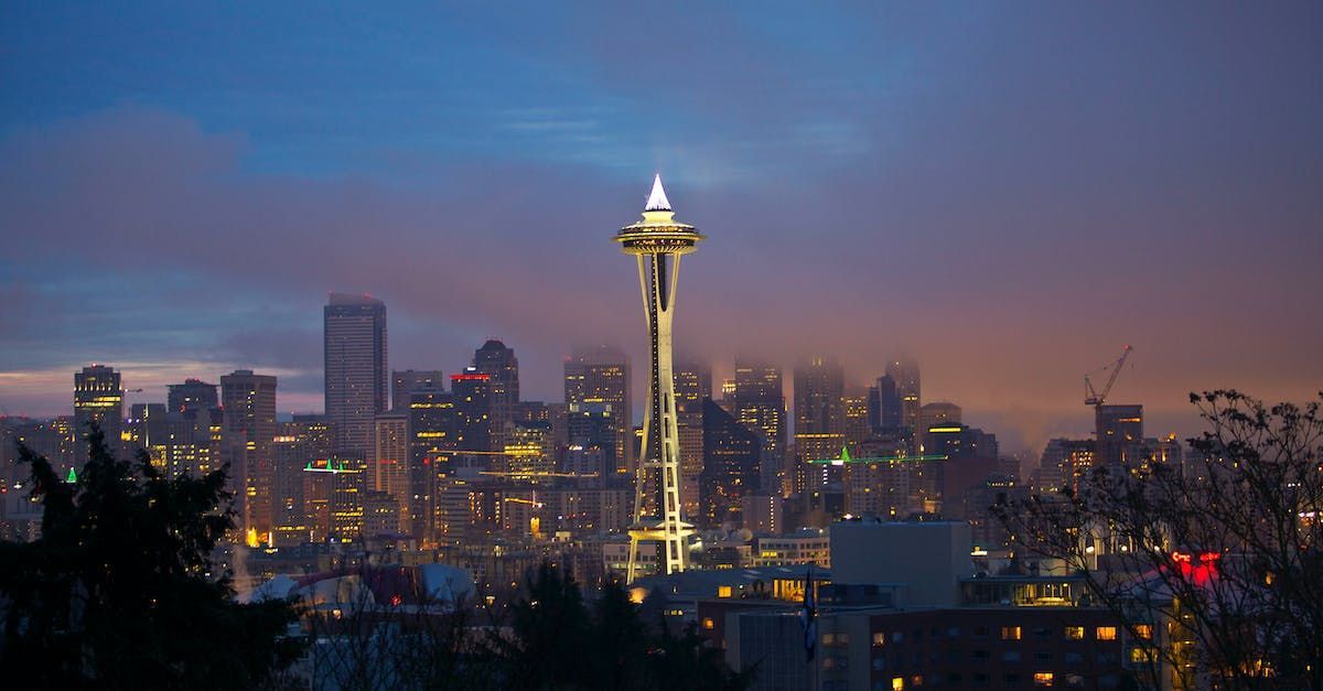 A view of a city skyline at night with the space needle in the foreground.