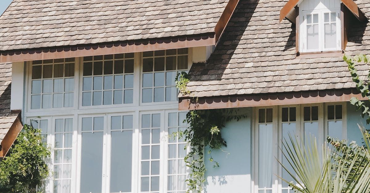 A house with a shingle roof and lots of windows