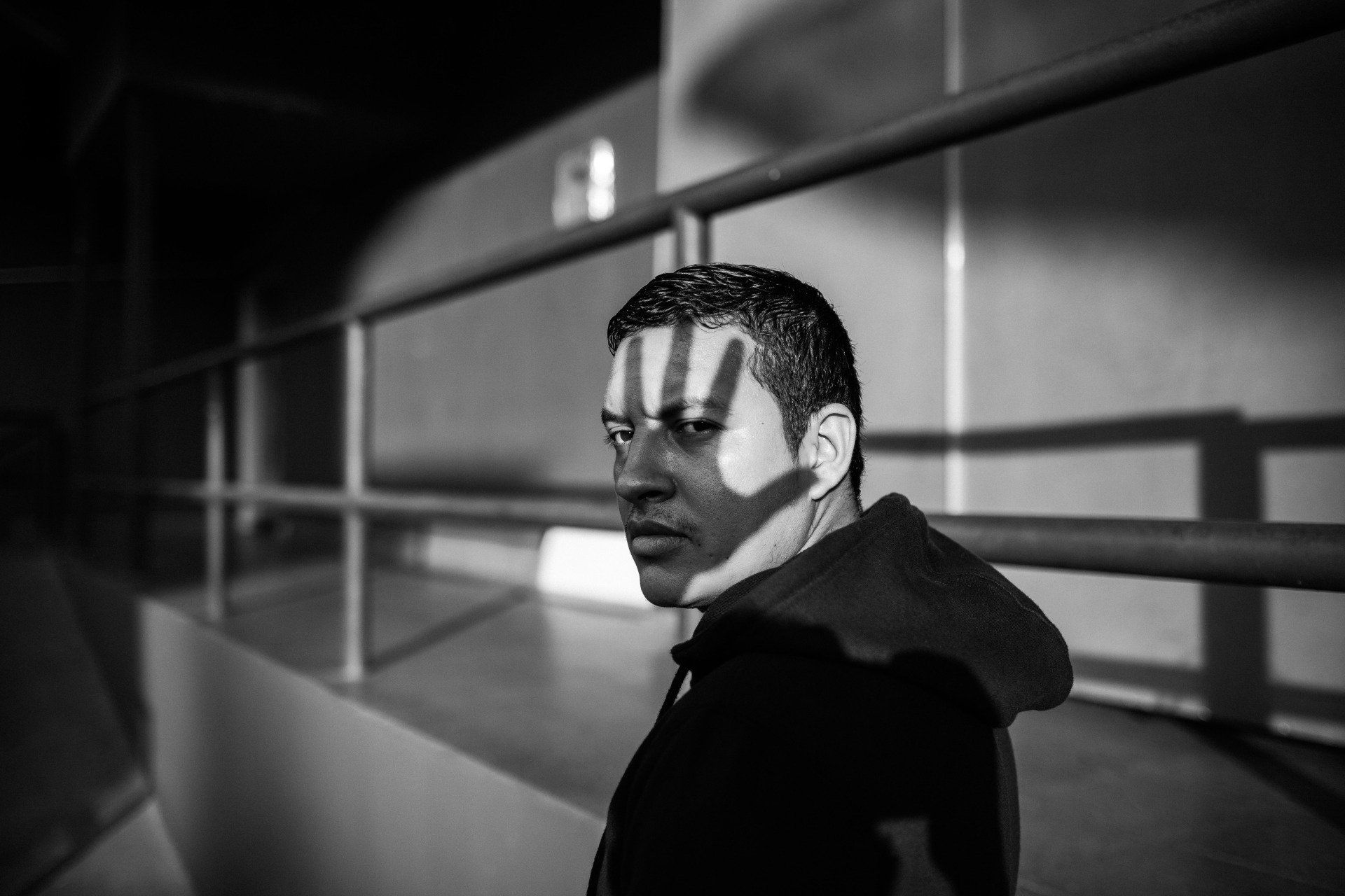 Black and white pic with a shadow of a hand over a Austin man's face  emphasizing the stigma