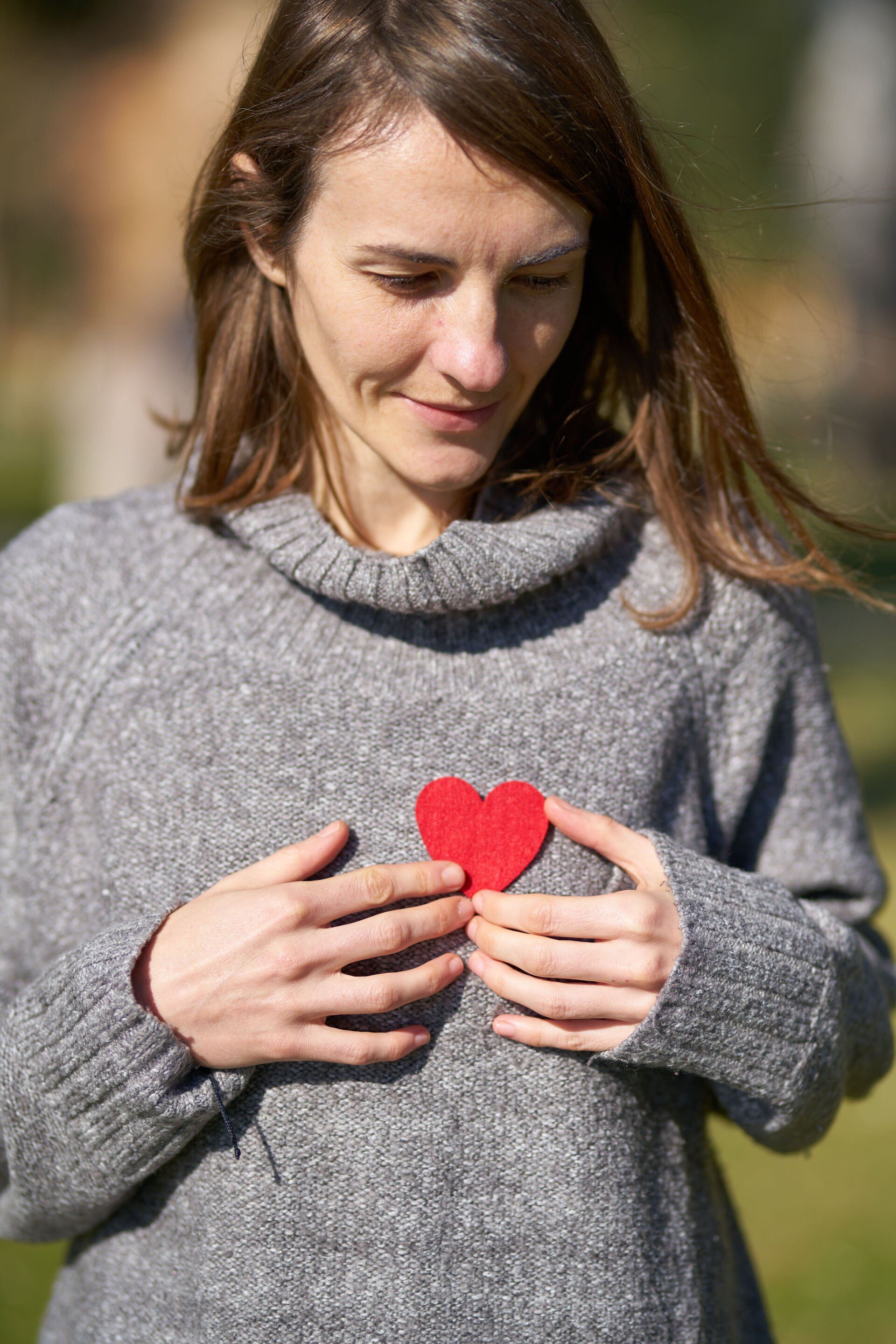 woman with a heart on hear sweater struggling with chronic illness