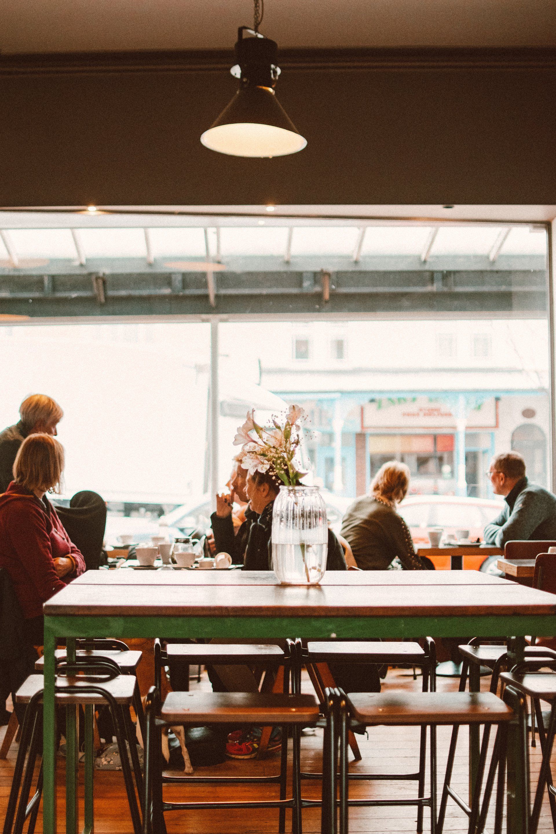 A group of people are sitting at tables in a restaurant.