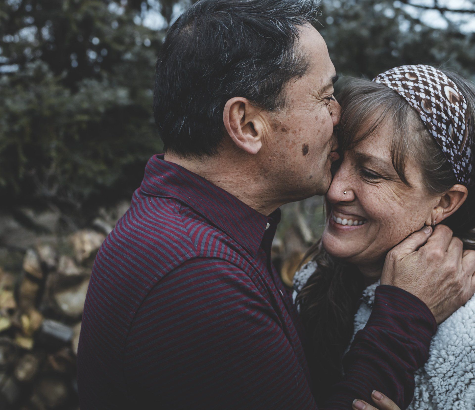 A man is kissing a woman on the cheek.
