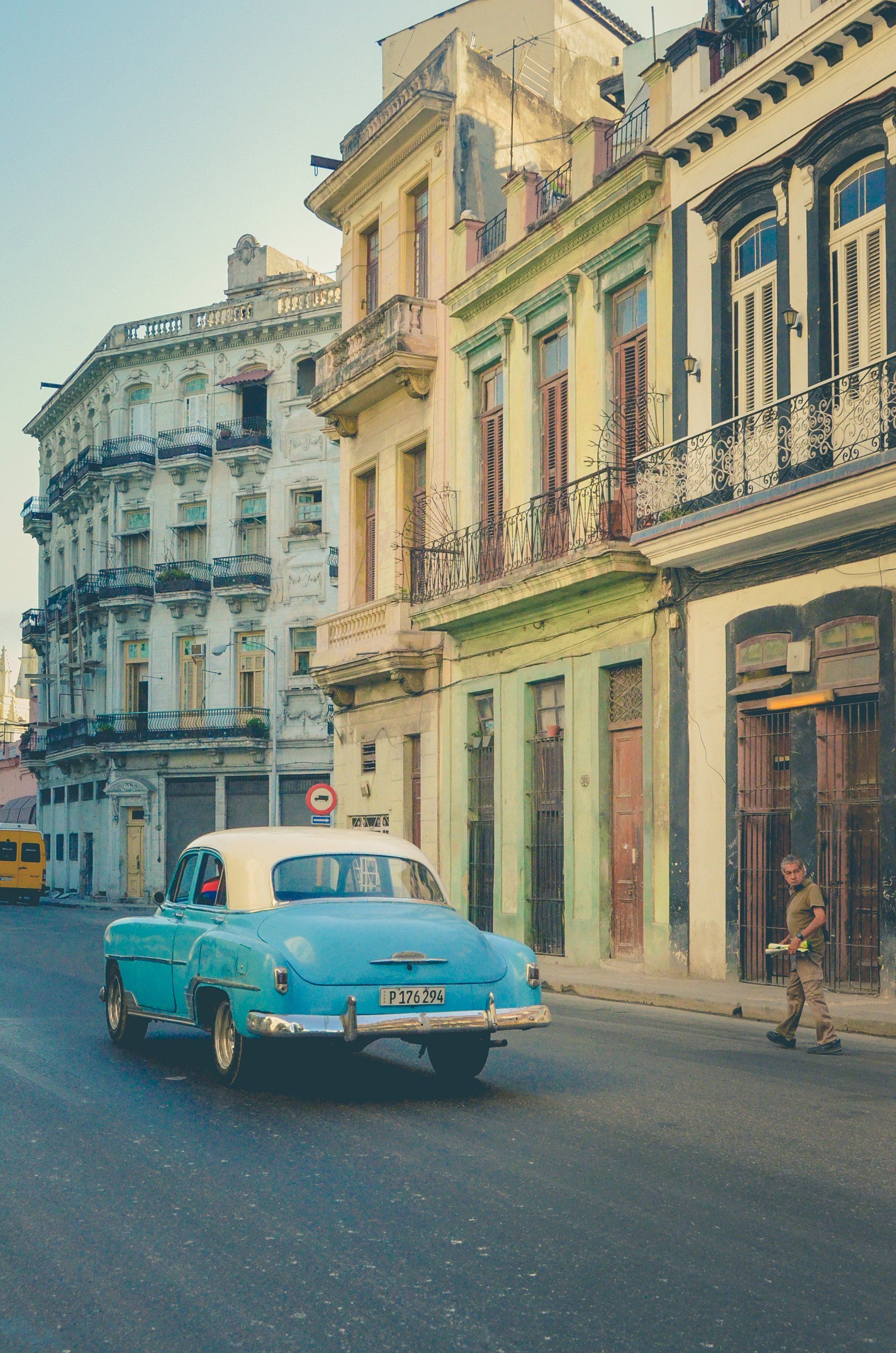 Un coche azul y blanco circula por una calle de la ciudad.