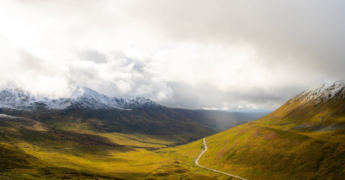 An aerial view of a mountain valley with a road going through it.