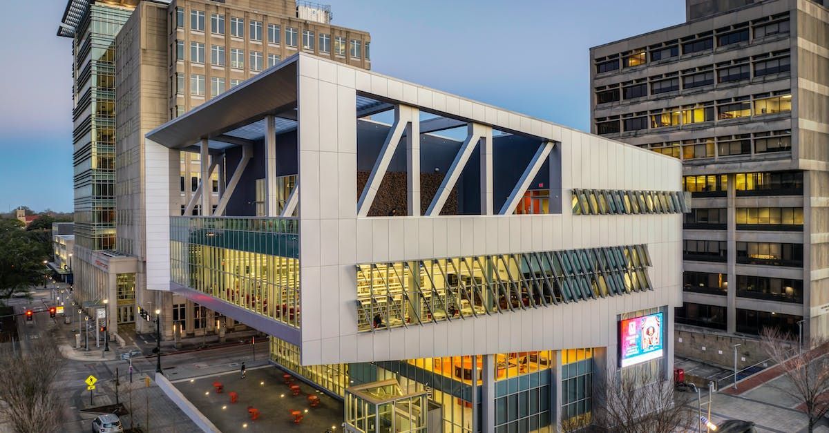 An aerial view of a large building with a lot of windows in a city.