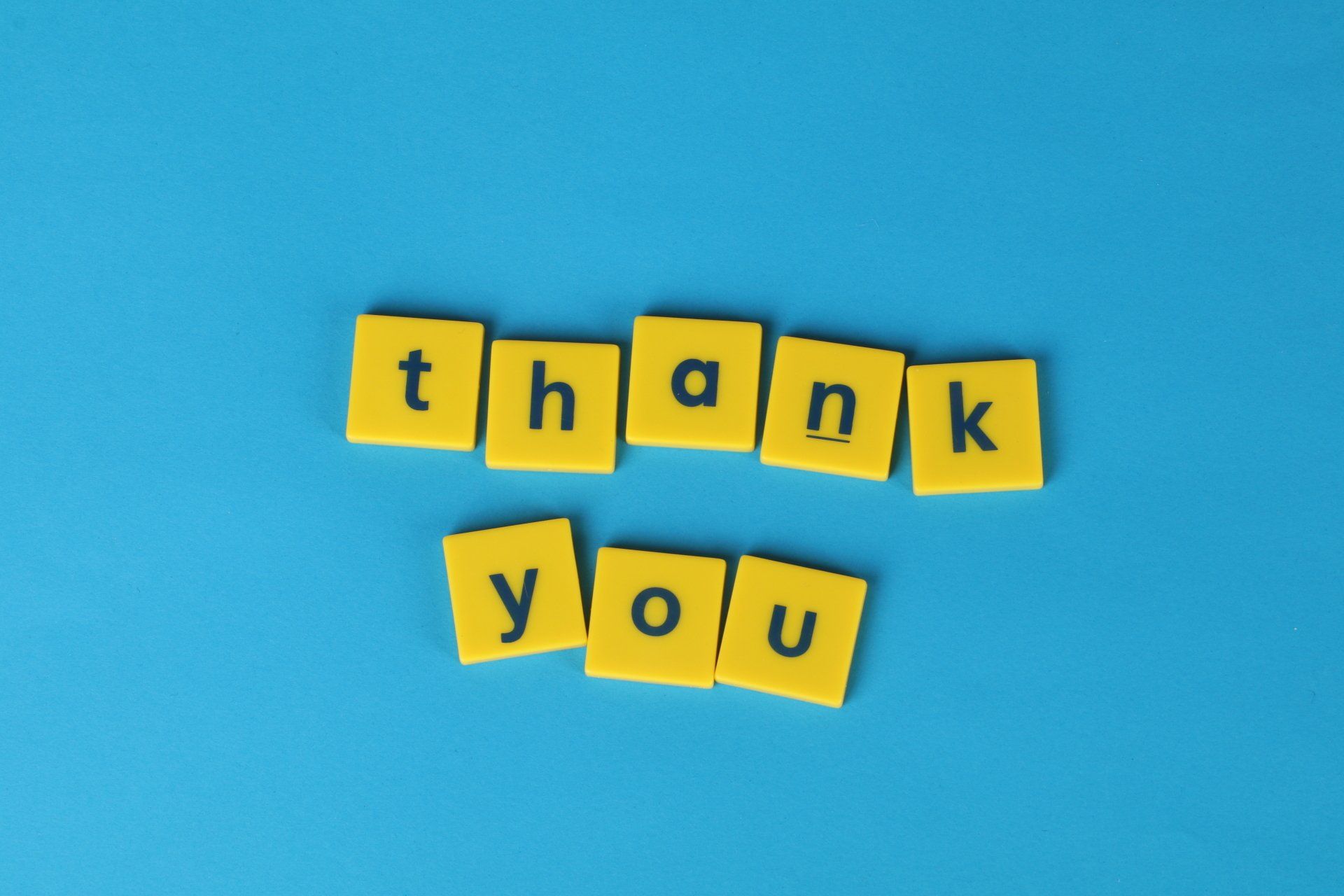 The word thank you is written in yellow blocks on a blue background.