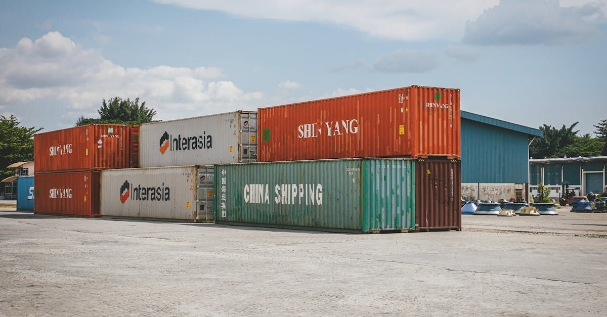 A row of shipping containers are stacked on top of each other in a parking lot.