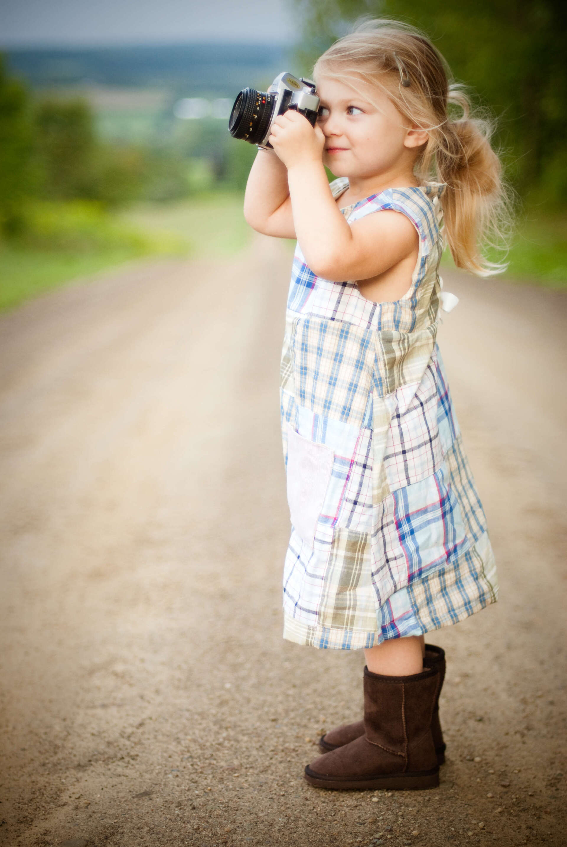 A little girl is taking a picture with a camera.
