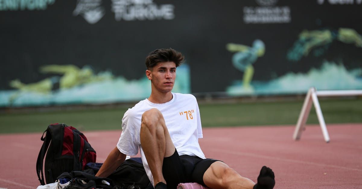 Sporter met klachten die op de grond zit, sportmassage kan klachten verlichten