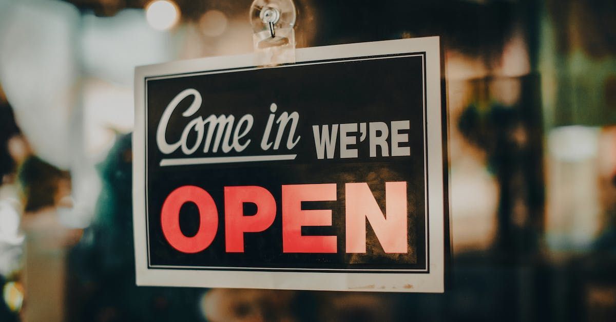 A sign that says `` come in we 're open '' is hanging on a window.
