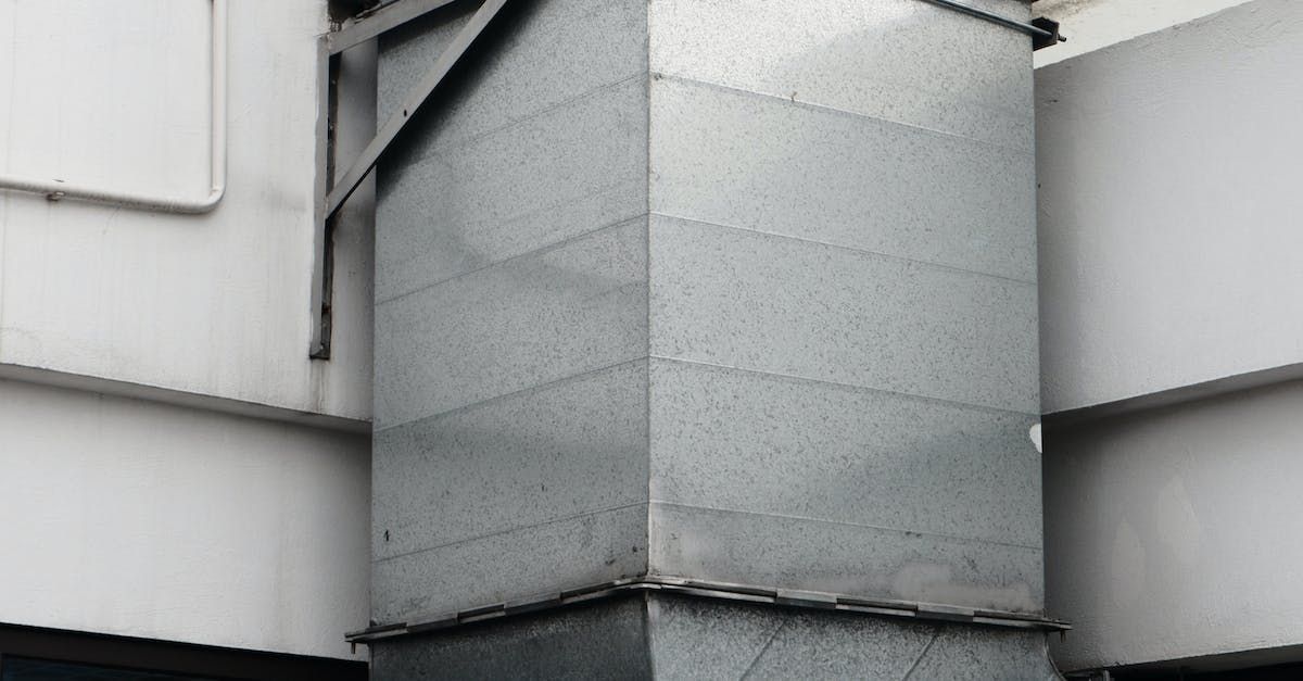 A large metal pipe is attached to the side of a building.