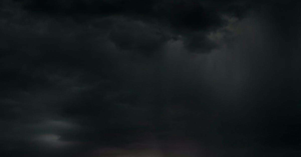 a dark cloudy sky with a few white clouds in it