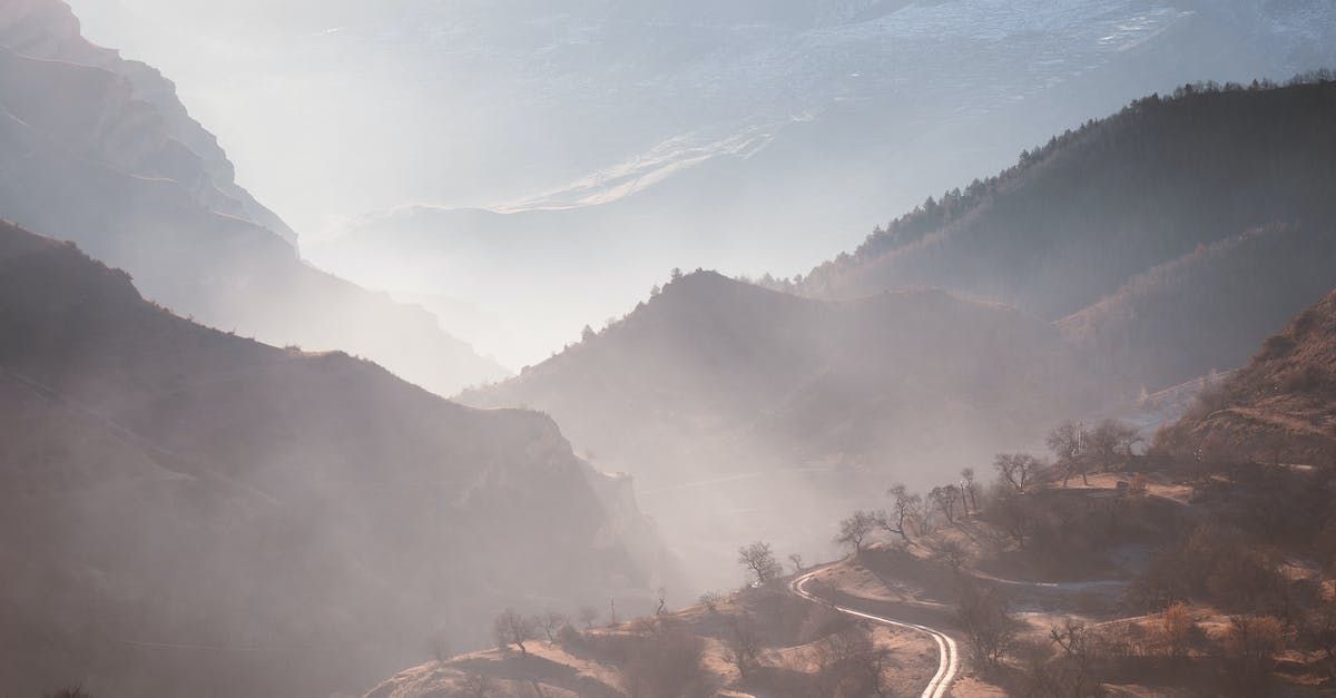 A road going through a foggy mountain valley.