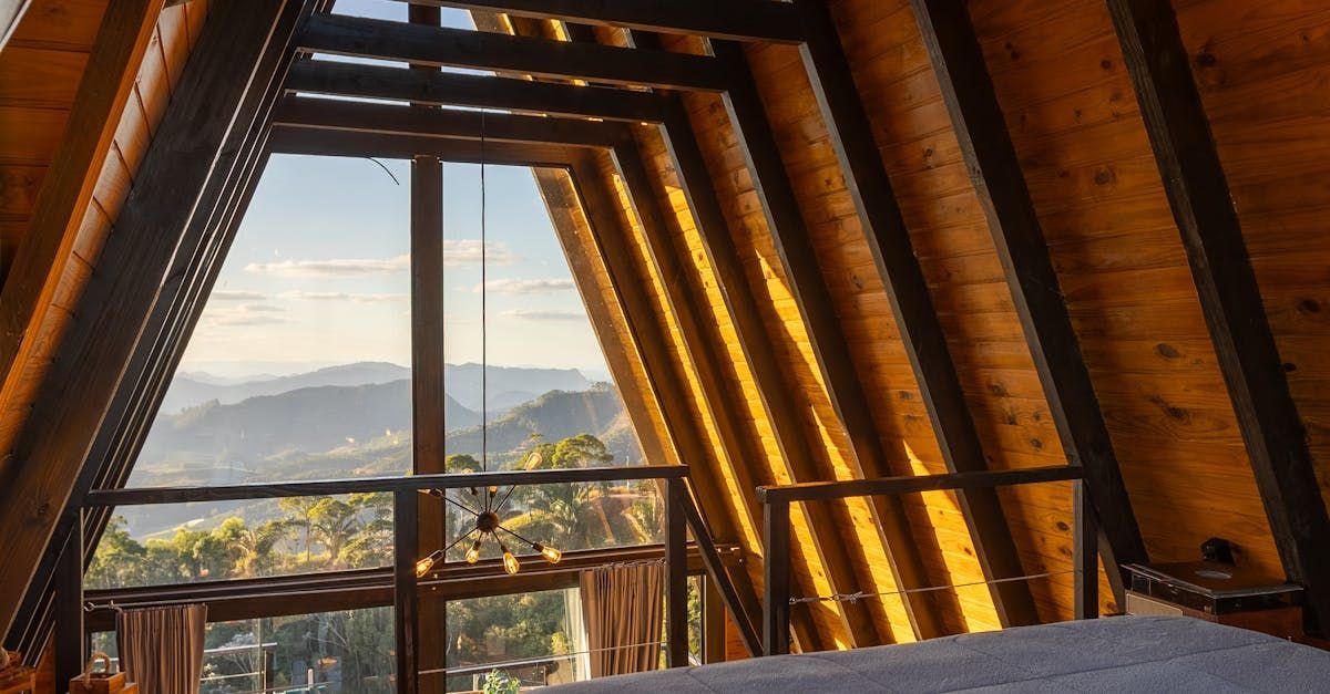 A bedroom in a wooden cabin with a view of the mountains.