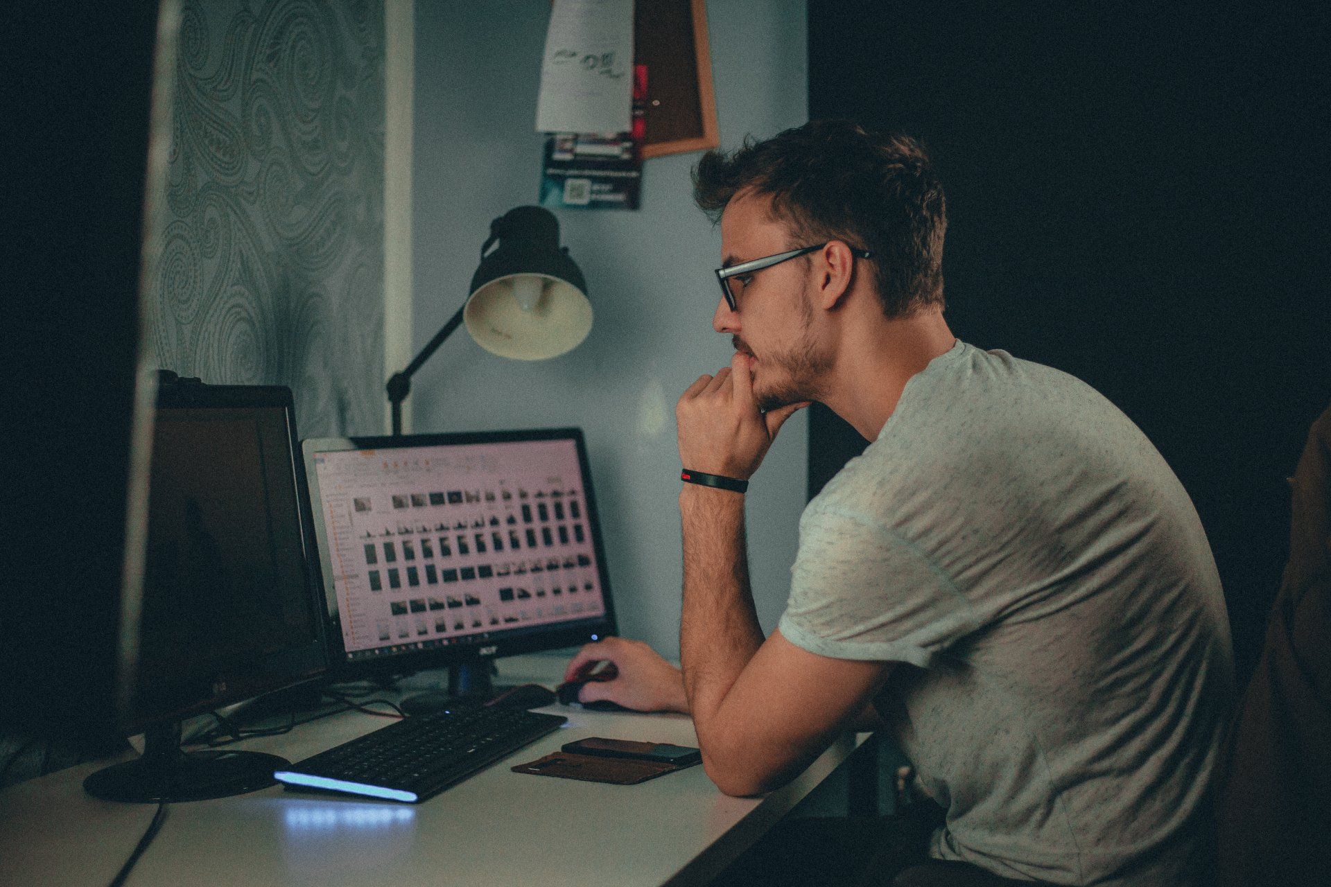 A man is sitting at a desk looking at a computer screen after getting an ISP copyright demand notice