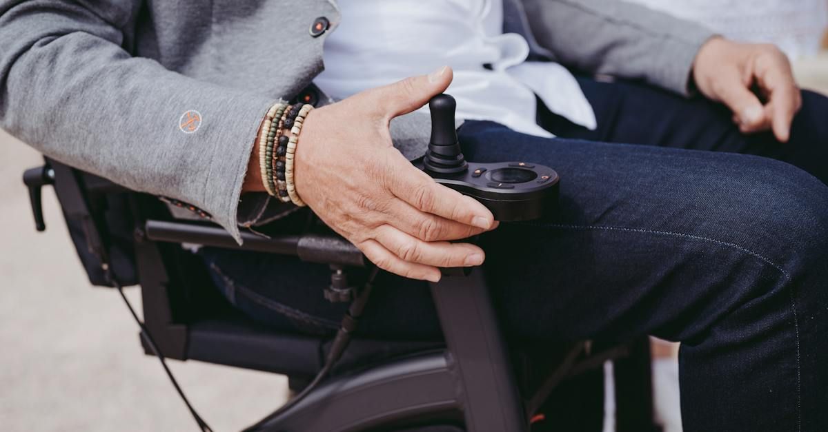 A man is sitting in a wheelchair holding a remote control.