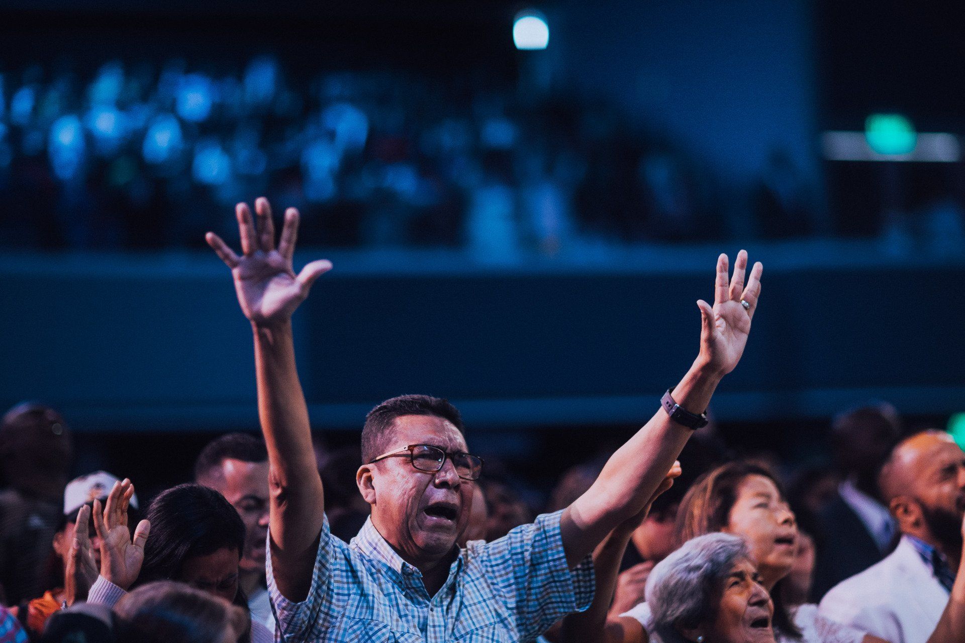 Man worshipping in church with hands lifted