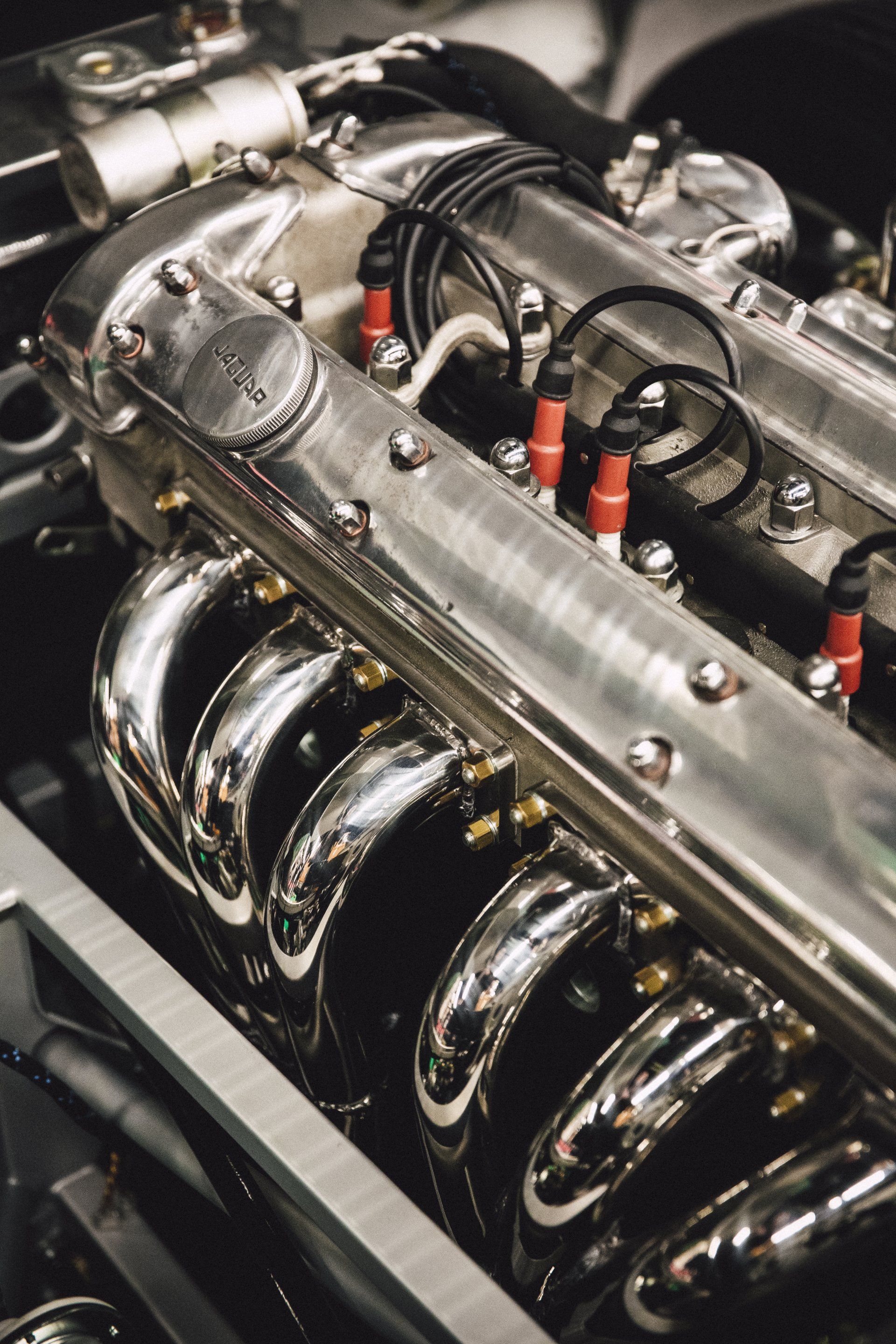 Close-up of a polished engine with chrome pipes and black components in a mechanical setting