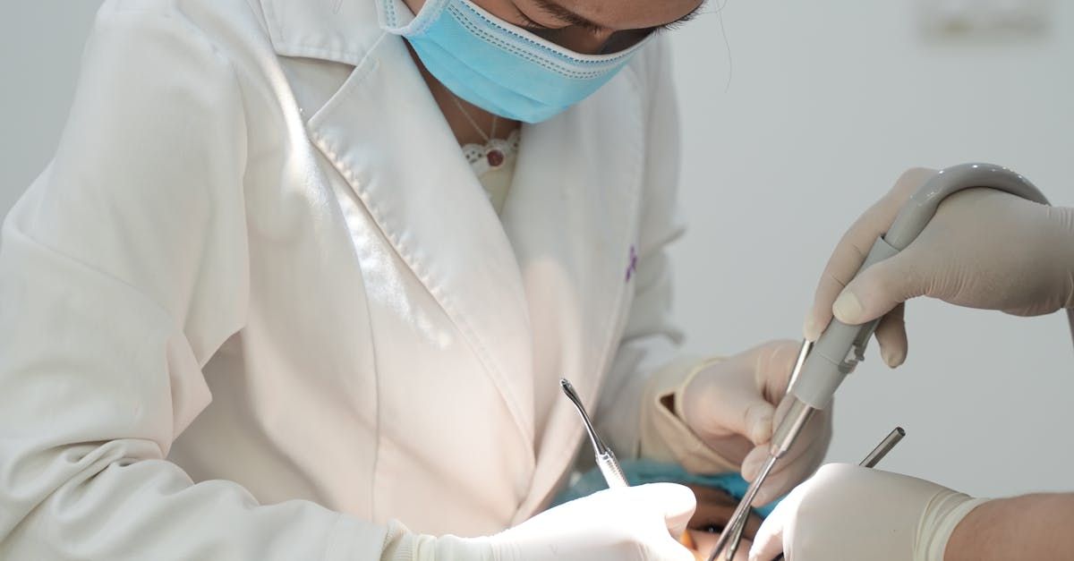 A dentist is working on a patient 's teeth in a dental office.