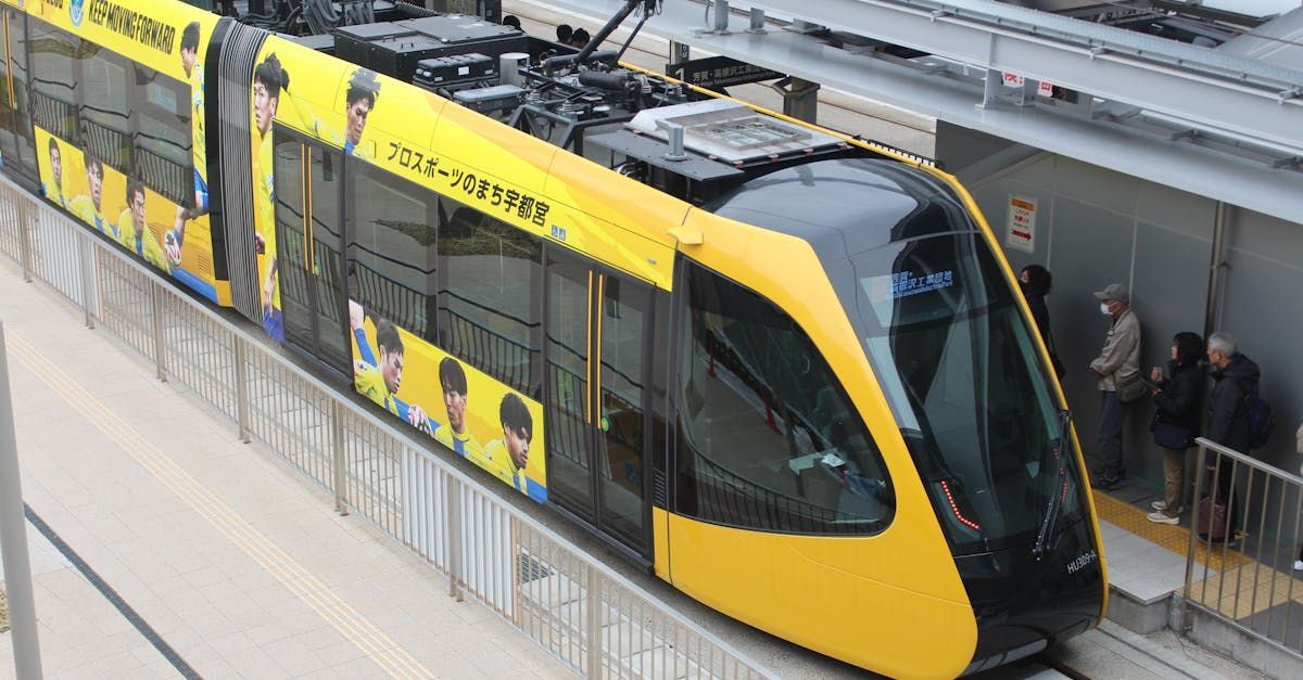 A yellow and black train is pulling into a train station.